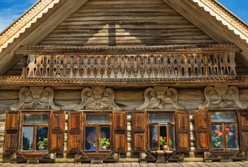 Fototapeta na wymiar Facade of an ancient wooden house in Russian traditional style in the Museum of Wooden Architecture of Vitoslavlitsa, Veliky Novgorod, Russia