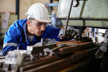 factory worker or technician checking and control lathe machine in factory