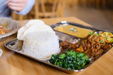 Chicken daal baht power (rice, spinach, lentil, pickle and chicken curry) served on a stainless steel tray at Tapari Nights, a Nepalese restaurant in Sydney, Australia