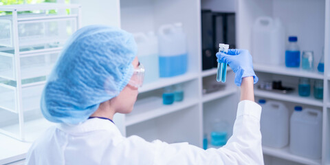 Professional expertise woman research scientist compare blue liquid in test tube or glassware...