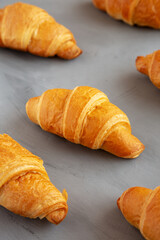 Homemade Croissants on a gray background, side view. © Liudmyla