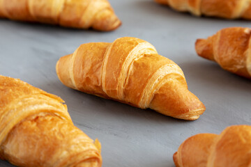 Homemade Croissants on a gray background, side view.