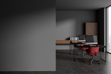 Grey office interior with pc monitors on table and shelf with window. Mock up wall