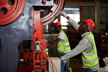 African factory workers or engineer using the machine and pointing pose in the factory