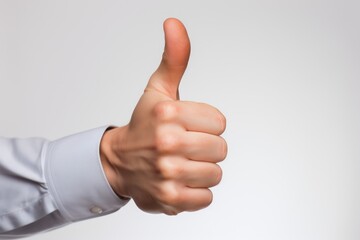 Close-up of a human hand showing thumbs up isolated on white background. Gesturing of trust, agreement, positive green signal, validation, like, and support.