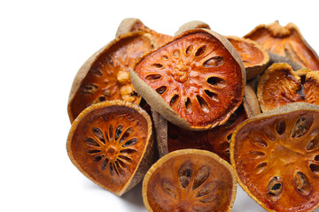 Dried bael fruit slices on white background.