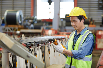 male factory worker or engineer operating remote switch to control machine in the factory
