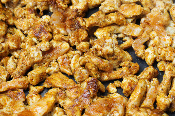 Making turkish doner kebab at home. Raw chicken pieces on frying pan. Marinated chicken in spices. Gyros dish recipe. Dinner frying background. Simple meat background. Closeup food texture.