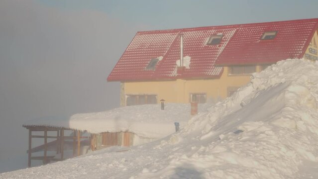 Snow pile of a two storey resorted houses height in the mountains. Thick heavy snow on heavy precipitation day.