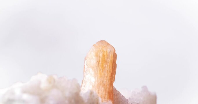 stilbite crystal on quartz matrix rotating 360&deg; on white blackground in 4k. macro detail  background. close-up Rough raw unpolished semi-precious gemstone.
