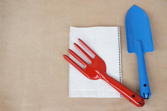 Blue shovel, red digging fork and white growing bag. Concept, gardening tools. Prepare equipment to planting or seeding.   