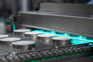 Manufacture of sour cream and yogurt. Industrial machine, stage of complete cleaning and sterilization of containers before filling at modern production plant, conveyor.