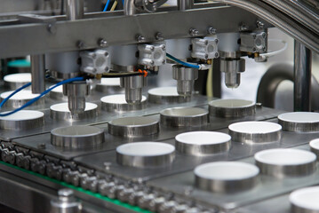 Close-up automated filling of cheese mass, sour cream or yoghurt into packages. Food production, dairy plant, line.
