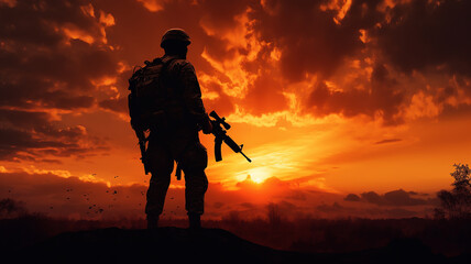 Soldier with a weapon silhouette against sunset