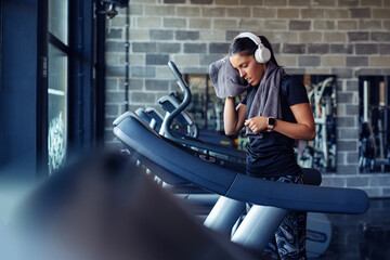 Fototapeta na wymiar Beautiful woman on a treadmill at the gym with a towel.