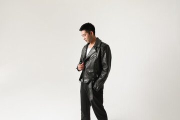 Portrait of a young handsome Asian wearing leather jacket posing indoor.