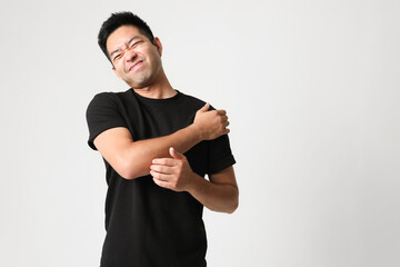 Fototapeta premium Portrait of Asian young man complaining of shoulder pain. Horizontal mock-up.