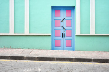 Street view of an old colonial building facade with wooden door, architecture background, Cuenca, Ecuador.