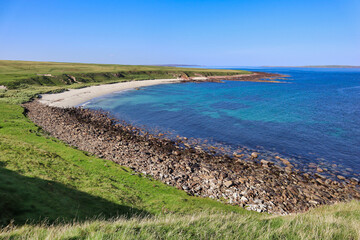 Blue water white sand scottish beach in scotland with grass and dunes