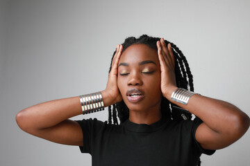 Thoughtful African American woman with long braids posing indoor. Mock-up.