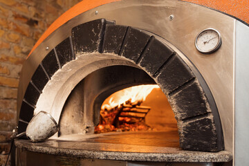 Pizza concept. Preparing traditional italian pizza. Long shovel for pizza, baking dough in a...