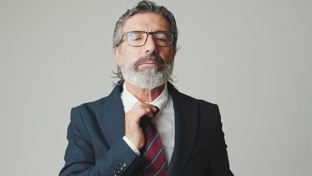 Middle aged businessman gesture of irritation, pulling his collar, isolated on gray background