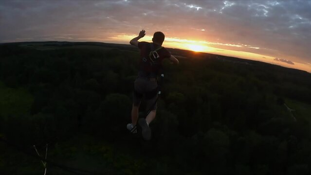 jump from a height, jump from a tower with belay, a guy jumps from a height with belay, a man jumps from a tower with belay, 
Slow motion
