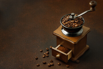coffee grinder with roasted beans on the brown table
