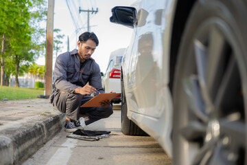 Auto mechanic inspects car by inspecting and writing checklist on clipboard. Mechanic checks car...