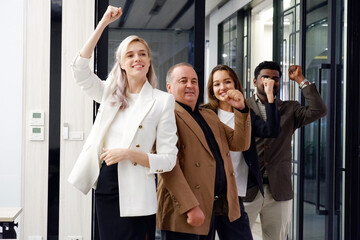 A businessman and a beautiful businesswoman stand and smile.