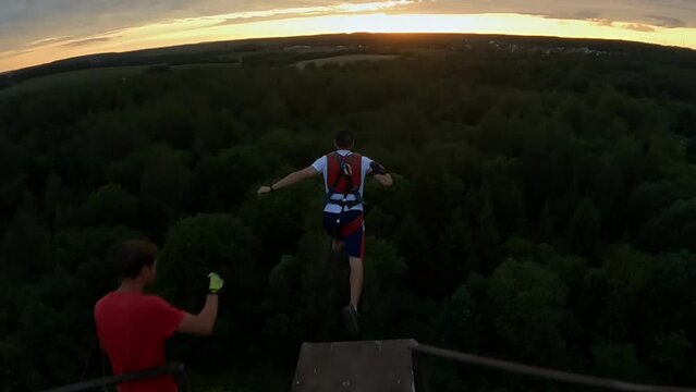 jump from a height, jump from a tower with belay, a guy jumps from a height with belay, a man jumps from a tower with belay, 
Slow motion