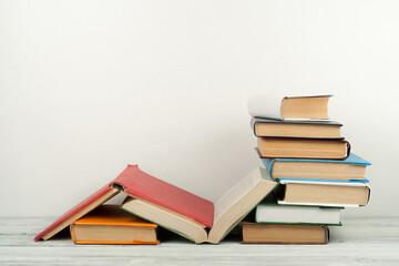 Open book, hardback colorful books on wooden table. Back to school. Copy space for text. Education business concept.