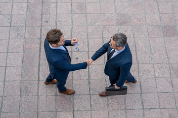 Successful teamwork. Business people shaking hands. Welcome business. Two businessmen shaking hands. Business men in suit shaking hands outdoors. Handshake between two businessmen.