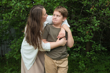 Fototapeta premium Beneath the trees, a heartwarming embrace between mother and son depicts a timeless love and familial bond