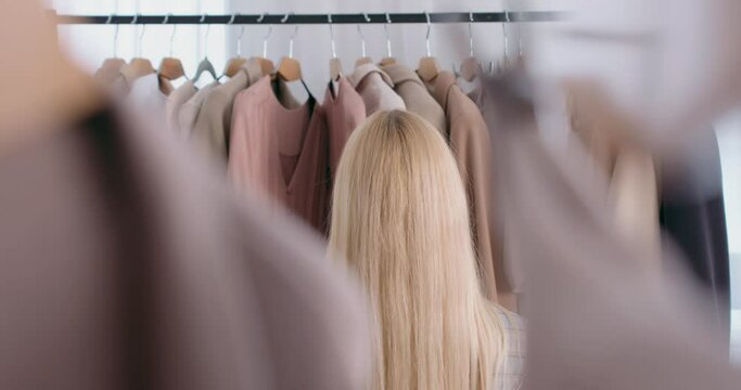 attractive smiling woman standing in dressing room happiness concept. fashion design studio store concept. blonde Caucasian female in jacket make choice