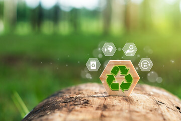 Recycling symbol on a wooden block placed in nature with a green background, with concept icons....