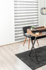 Wooden Brown Writing Desk with Storage and Black Metal Legs, Featuring Office Work Accessories, Accompanied by a Leather Office Chair, in a Room Illuminated by a Window, Home Office Concept.