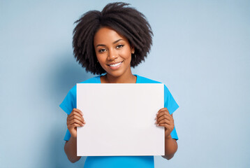 Black woman holding white sign paper in her hands and smiling at the camera with blue...