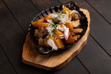 Dzhiz-Byz or Jiz-Biz with lamb, potatoes and onions on rustic background. Azerbaijan dish.