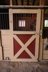 Interior shot of wooden horse stable with stalls inside the barn