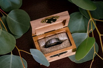 Men's chrome ring in a burlap decorate box on eucalyptus leaves
