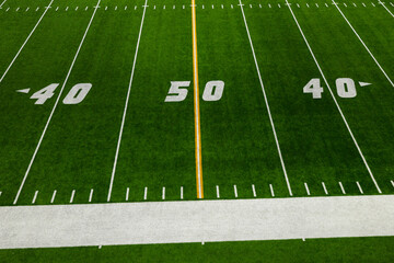 Obraz premium Football 50 Yard Line with yellow stripe and green artificial turf