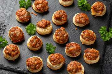 Cheese and BBQ sauce beans on mini crumpets. Party Finger food concept.