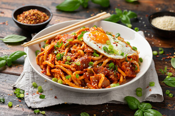 Kimchi Fried Udon Noodle with Fried Egg and bacon. Korean food.
