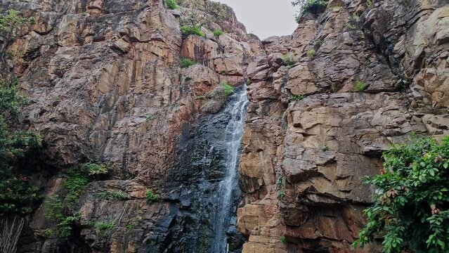 A beautiful view of a cascading holy waterfall from the top of the mountain