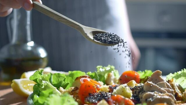 chia seeds in wooden spoon close up. seeds falling slow motion, healthy food, ceasar salad