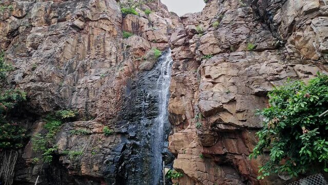 A beautiful view of a cascading holy waterfall from the top of the mountain