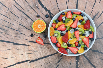 Fresh fruit salad bowl on wood grain table concept healthy food, to control weight, to lose weight