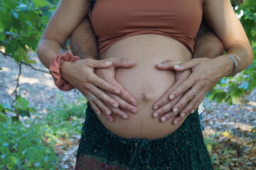 Manos de padre y madre en la barriga. Padres primerizos.