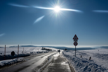 Road in nature with snow and sun
